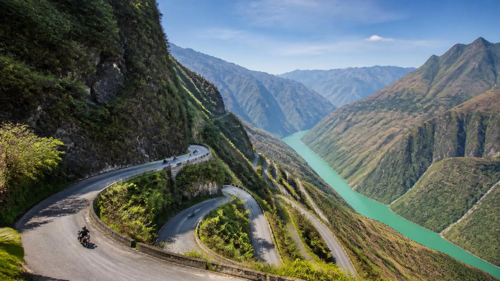 The legendary Ma Pi Leng Pass with hairpin curves carved into limestone cliffs, connecting Dong Van and Meo Vac in Ha Giang